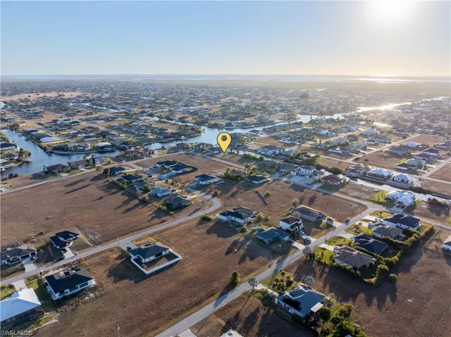 Aerial view of property and surrounding area featuring nearby suburban area and a large body of water