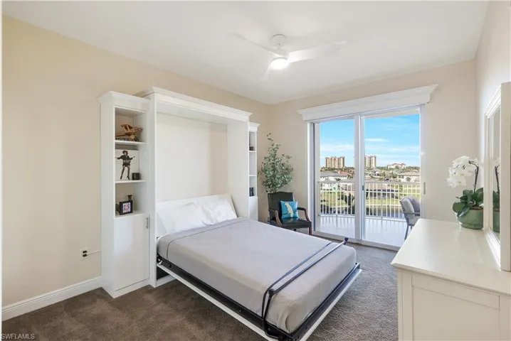 Bedroom featuring dark colored carpet, ceiling fan, and access to exterior
