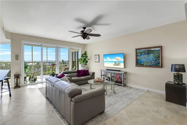 Tiled living room with ceiling fan and a healthy amount of sunlight