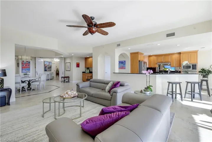 Living room with ceiling fan with notable chandelier