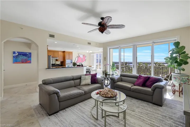 Living room with ceiling fan with notable chandelier
