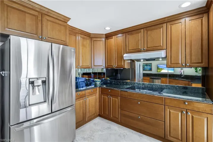 Kitchen featuring dark stone countertops and stainless steel appliances