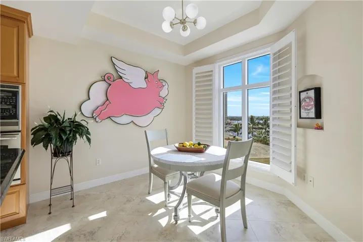 Dining space with a raised ceiling and a notable chandelier