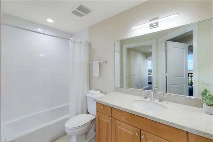 Full bathroom with toilet, vanity, and shower / tub combo with curtain