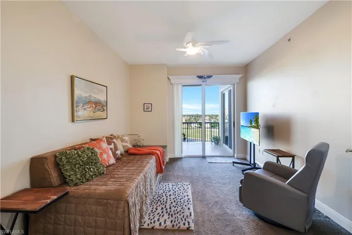 Carpeted living room featuring ceiling fan