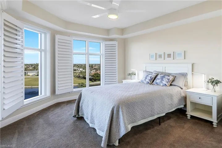 Carpeted bedroom featuring ceiling fan