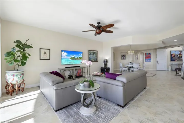 Living room featuring ceiling fan with notable chandelier