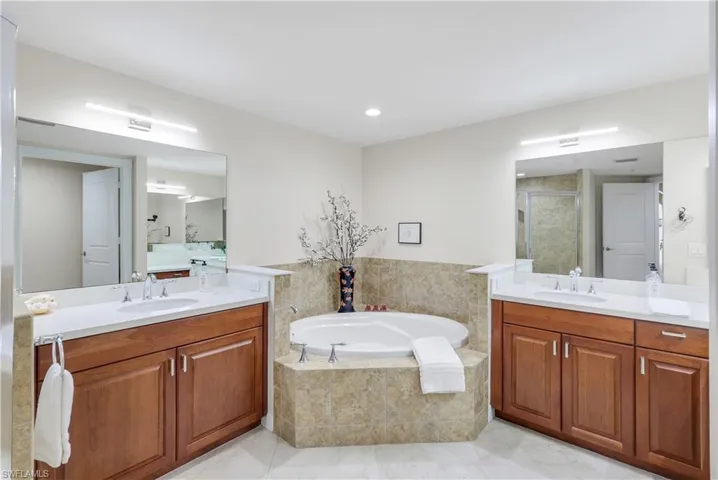 Bathroom with separate shower and tub, tile patterned flooring, and vanity