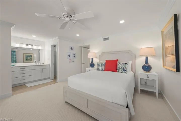 Spacious bedroom with light-toned carpeting and an integrated ensuite featuring a double vanity with light cabinetry