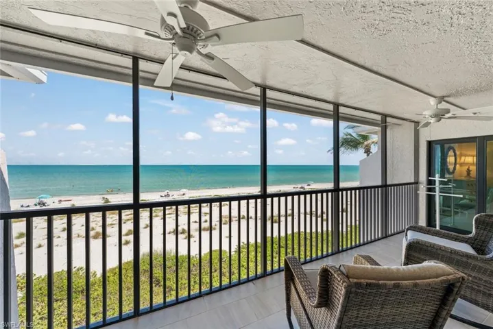 Screened balcony featuring expansive beach and ocean scenery