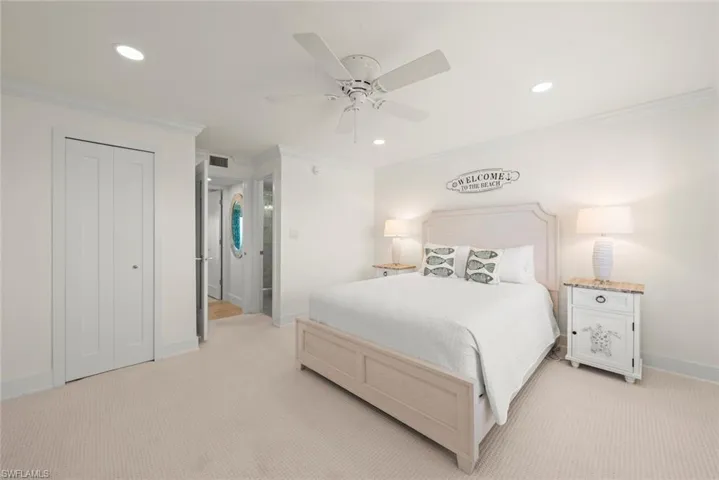 Carpeted bedroom featuring a ceiling fan, recessed lighting, crown molding, and bifold closet doors