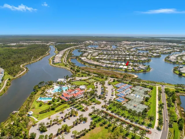 Aerial view of property and surrounding area featuring a nearby body of water and nearby suburban area