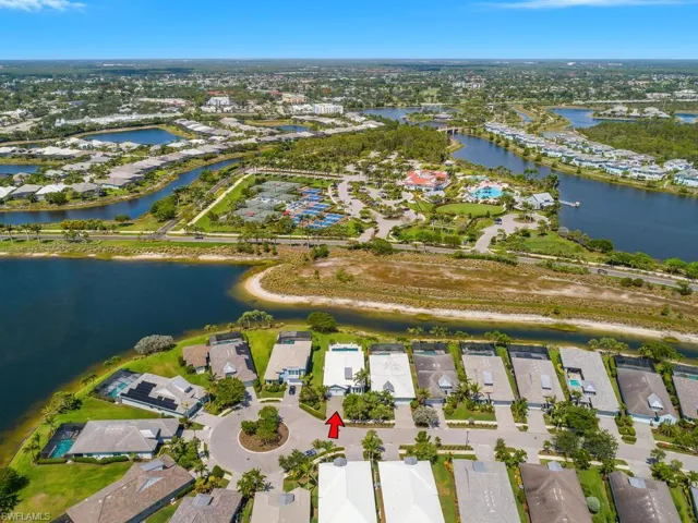 Aerial view of property and surrounding area featuring nearby suburban area and a large body of water
