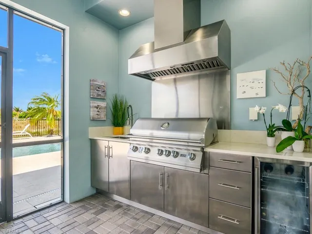 Outdoor Kitchen, wine cooler, brick patterned floors, and light countertops