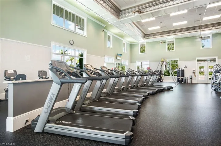 Gym with a high ceiling, crown molding, and ceiling fan