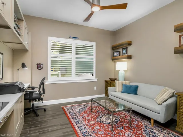 Office space featuring a ceiling fan, baseboards, and dark wood-type flooring