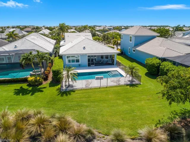 Rear view of property featuring a residential view, an outdoor pool, and lots of green space.