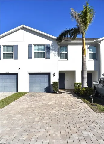 View of front of home with stucco siding, a garage, and driveway
