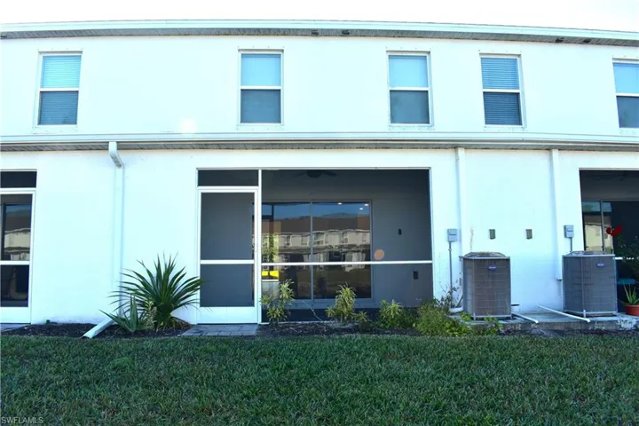 Back of house featuring stucco siding and a yard
