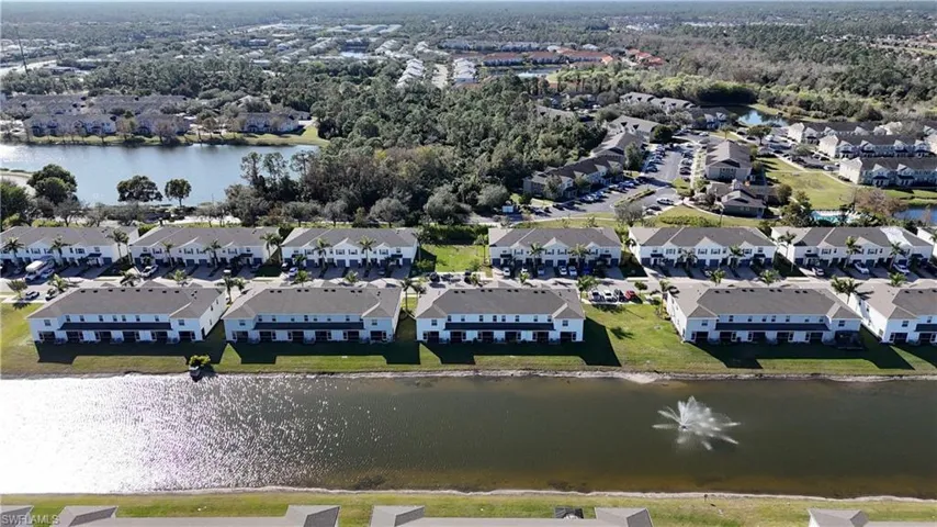 Aerial view of property's location featuring a nearby body of water and nearby suburban area