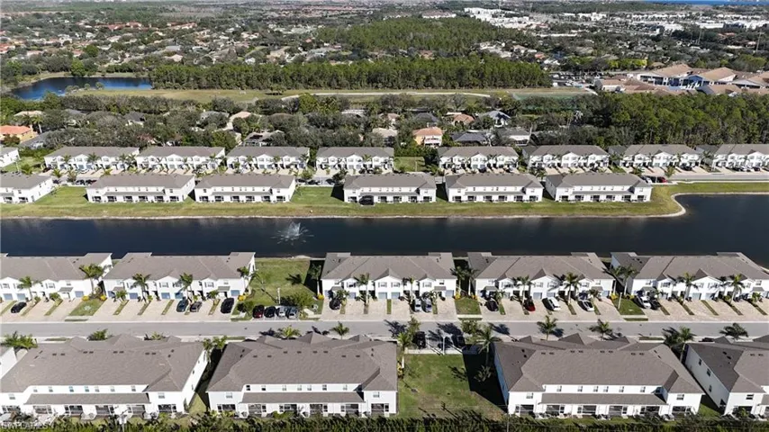 Aerial view of property's location featuring a nearby body of water and nearby suburban area