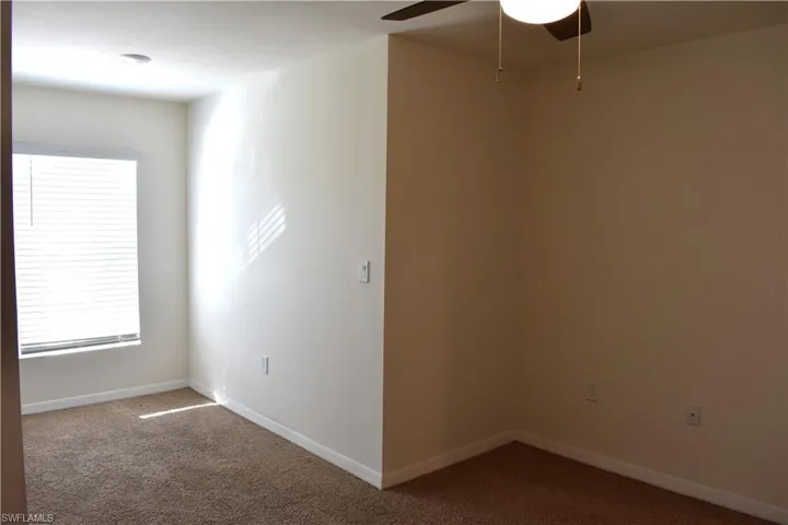 Empty room with carpet floors and ceiling fan