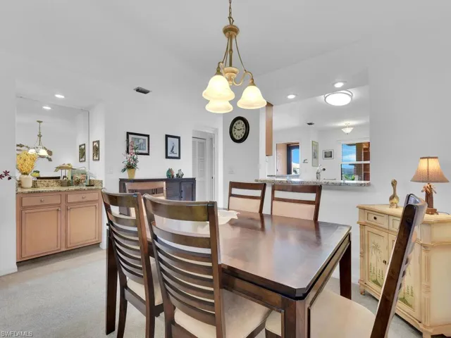Carpeted dining space with an inviting chandelier