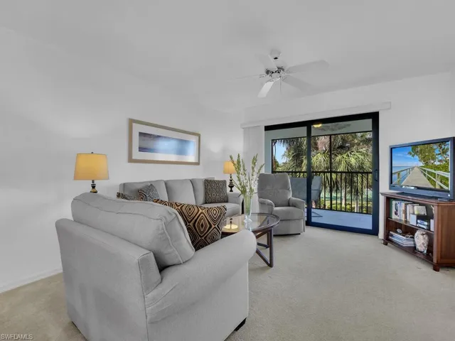 Carpeted living room featuring ceiling fan
