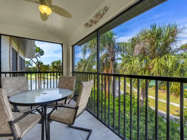 Sunroom / solarium with ceiling fan and a water view
