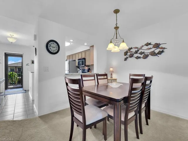 Carpeted dining room featuring a chandelier