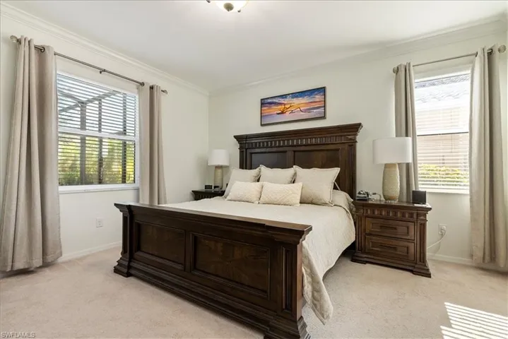 Bedroom with light colored carpet and ornamental molding