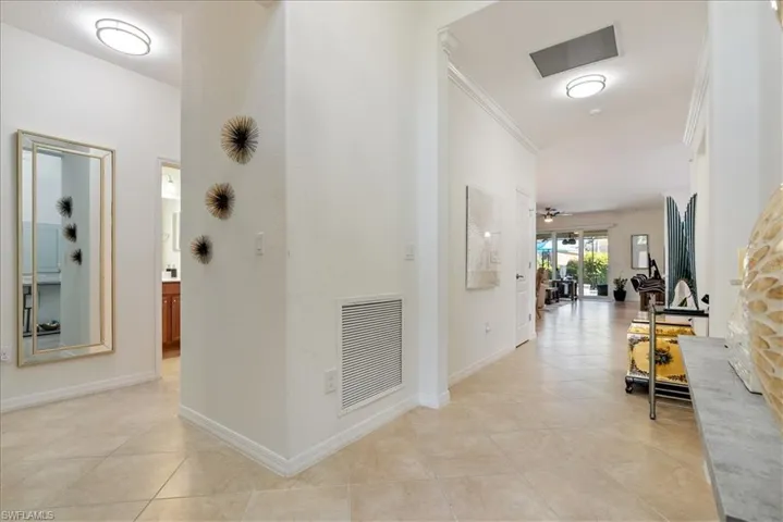 Hall featuring light tile patterned floors and crown molding
