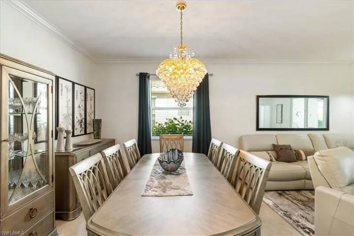 Dining space with a chandelier and crown molding