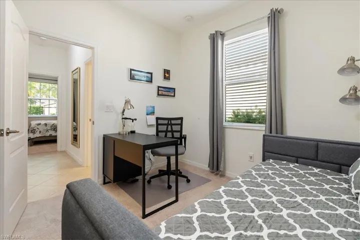 Bedroom featuring a desk and light colored carpet