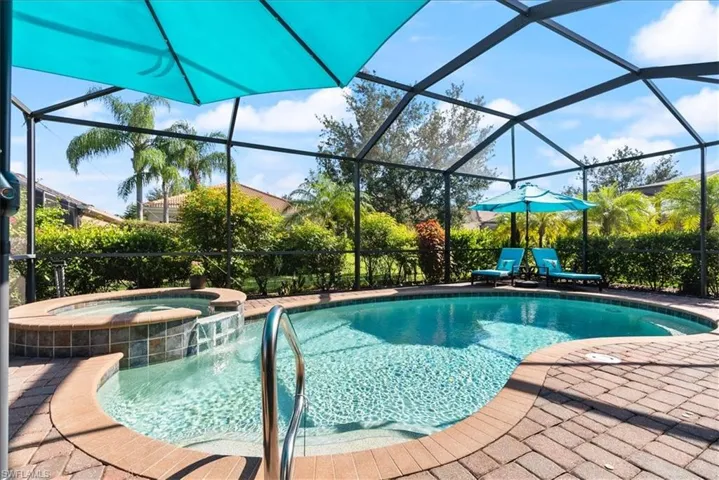 View of swimming pool with a pool with connected hot tub, a lanai, and a patio