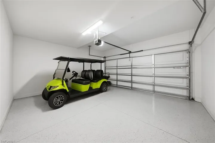 Garage with baseboards and a garage door opener