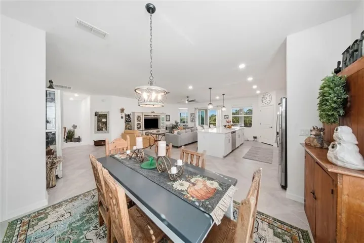 Dining space featuring recessed lighting, a ceiling fan, a chandelier, and light tile patterned floors
