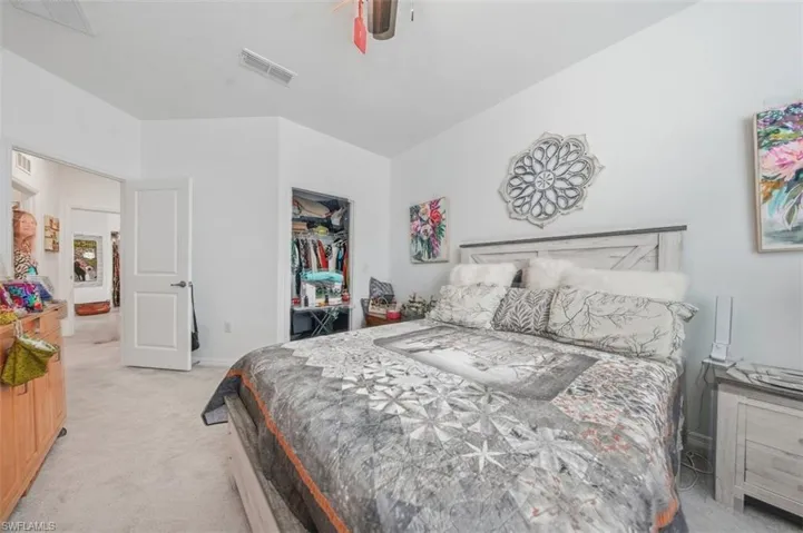 Bedroom with light colored carpet and a closet