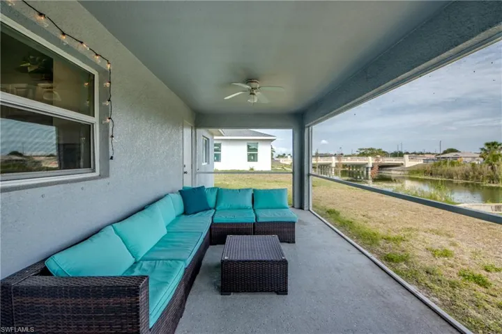 Screened patio featuring a ceiling fan and concrete flooring