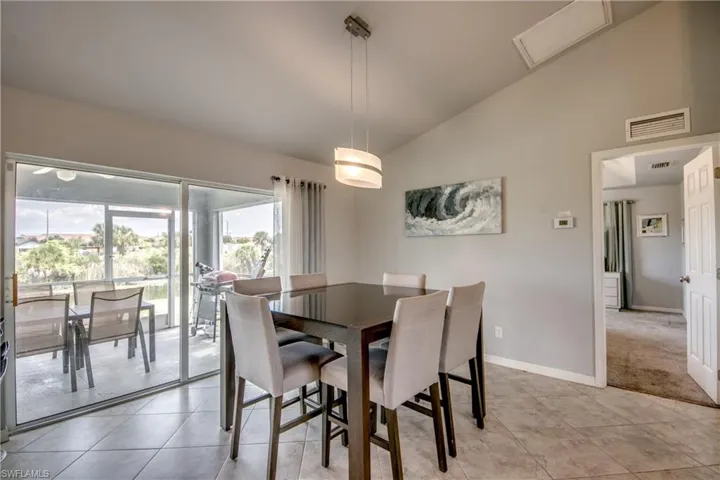 Dining area with vaulted ceiling and contemporary pendant lighting