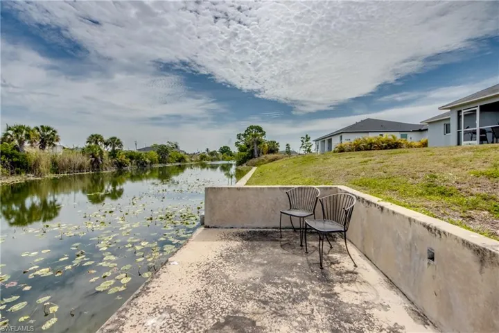 Waterside concrete patio with a curved retaining wall, offering direct access to the canal