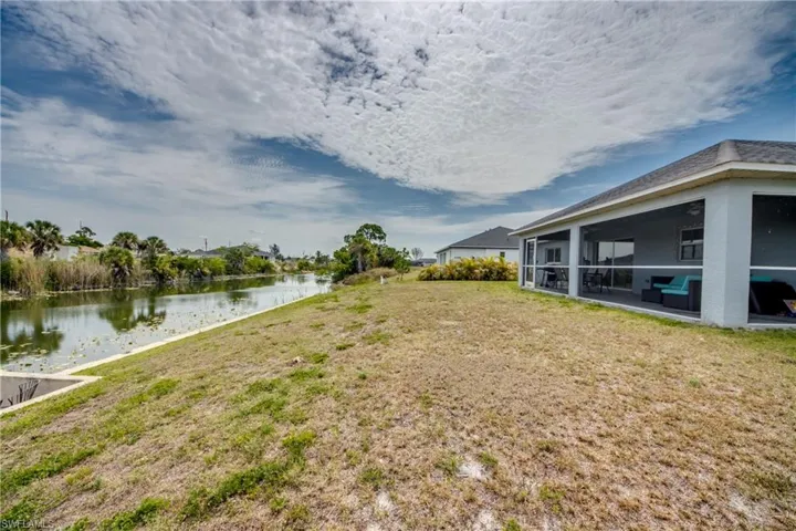 Waterfront property featuring a screened porch and a substantial grassy area