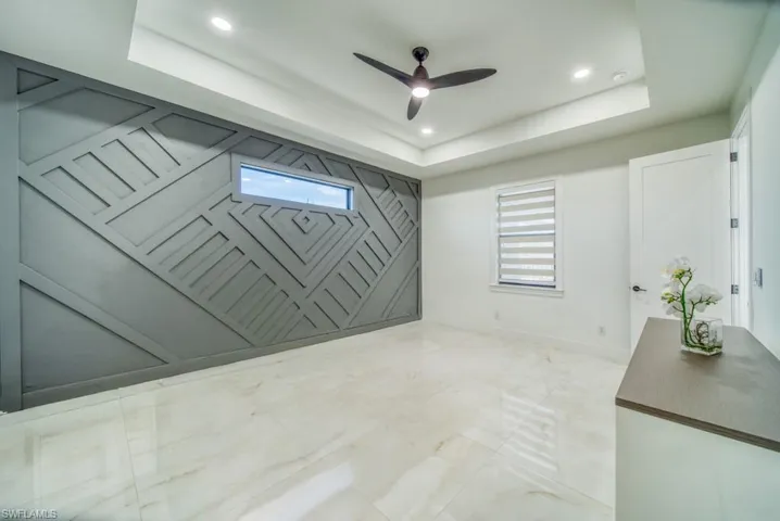 Unfurnished room with a ceiling fan, recessed lighting, and a raised ceiling