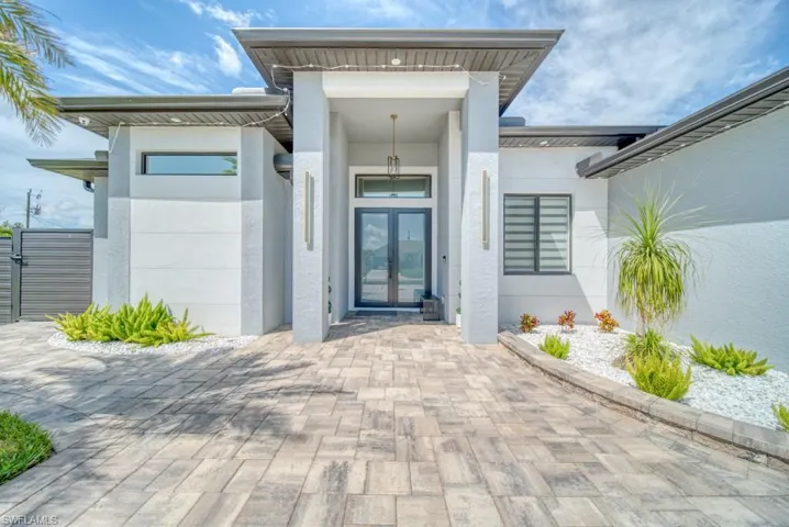 Entrance to property featuring stucco siding and french doors