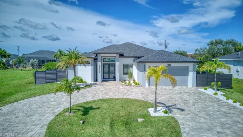 View of front of home featuring stucco siding, a garage, decorative driveway, and roof with shingles