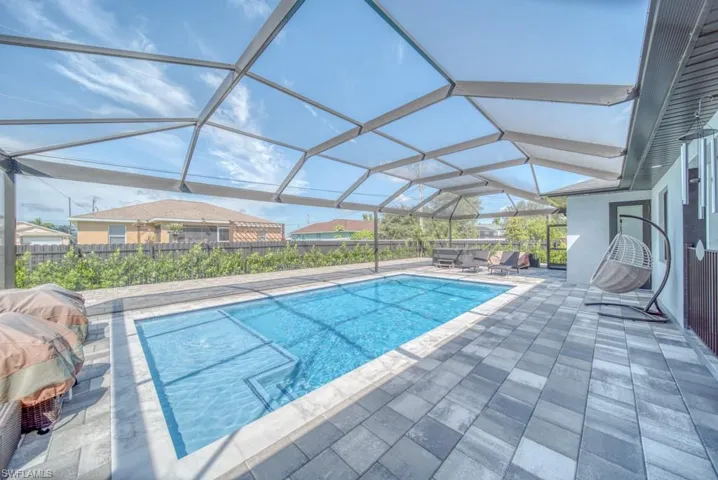 Swimming pool with a sunroom, a patio area, and a lanai