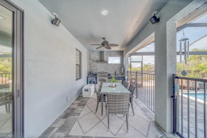 View of patio / terrace with a sunroom, area for grilling, a ceiling fan, outdoor dining space, and glass enclosure