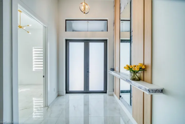 Entryway with a chandelier, marble finish flooring, and plenty of natural light