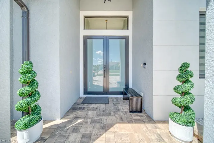 Doorway to property featuring french doors and stucco siding