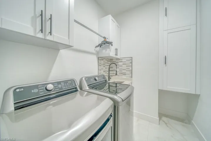 Washroom featuring cabinet space and independent washer and dryer
